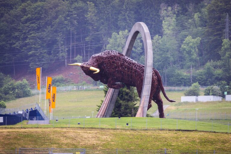 Large bull sculpture at Red Bull Ring circuit with lush green backdrop.